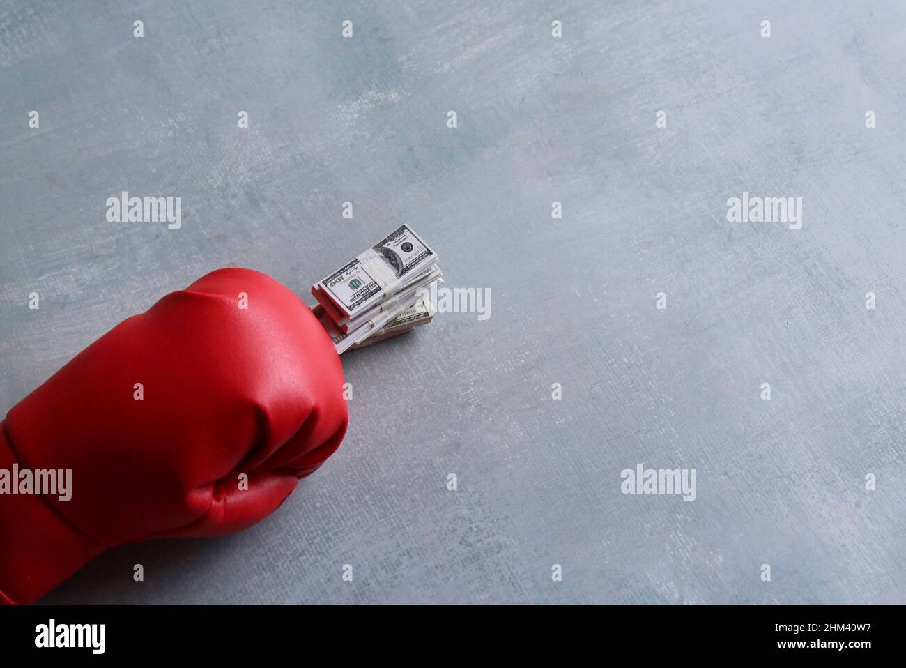 Red boxing gloves and stack of dollars bills. Sports for money. Copy