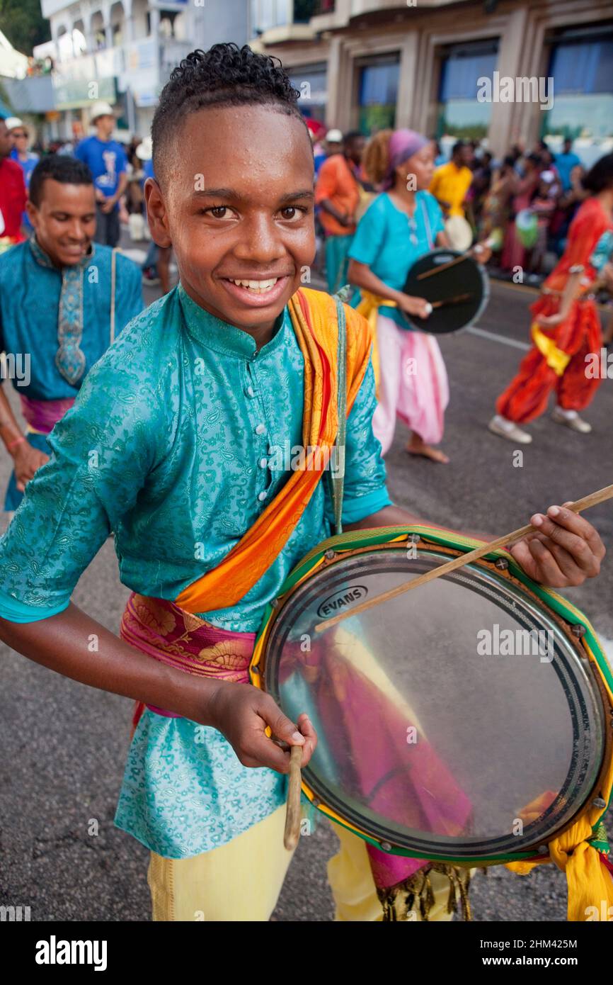 Young drummer boy performing in the street during carnival in the Seychelles. Stock Photo