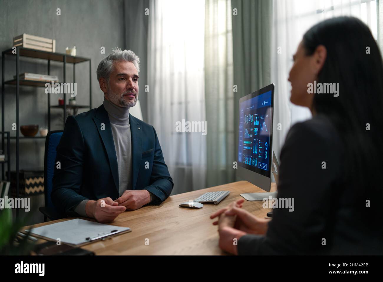 Mature financial advisor consulting with his client indoors in office. Stock Photo