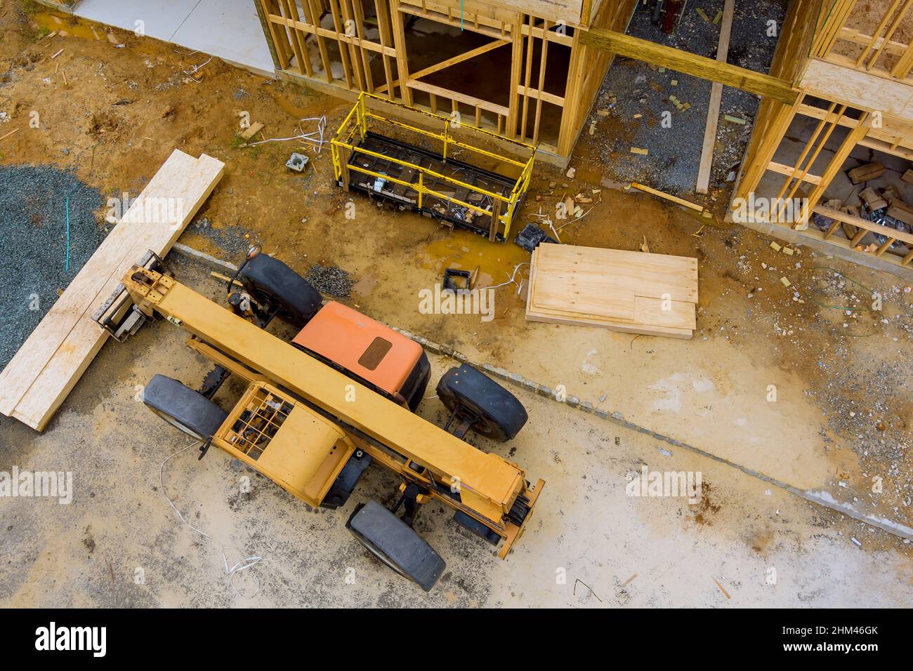 A boom truck forklift loaded with wooden board for new bilding at a working construction Stock