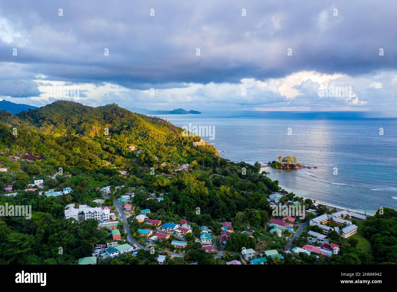 Mahe Island with Port Glaud village drone landscape, with lush tropical forest of Morne Seychellois National Park and Indian Ocean on the horizon. Stock Photo