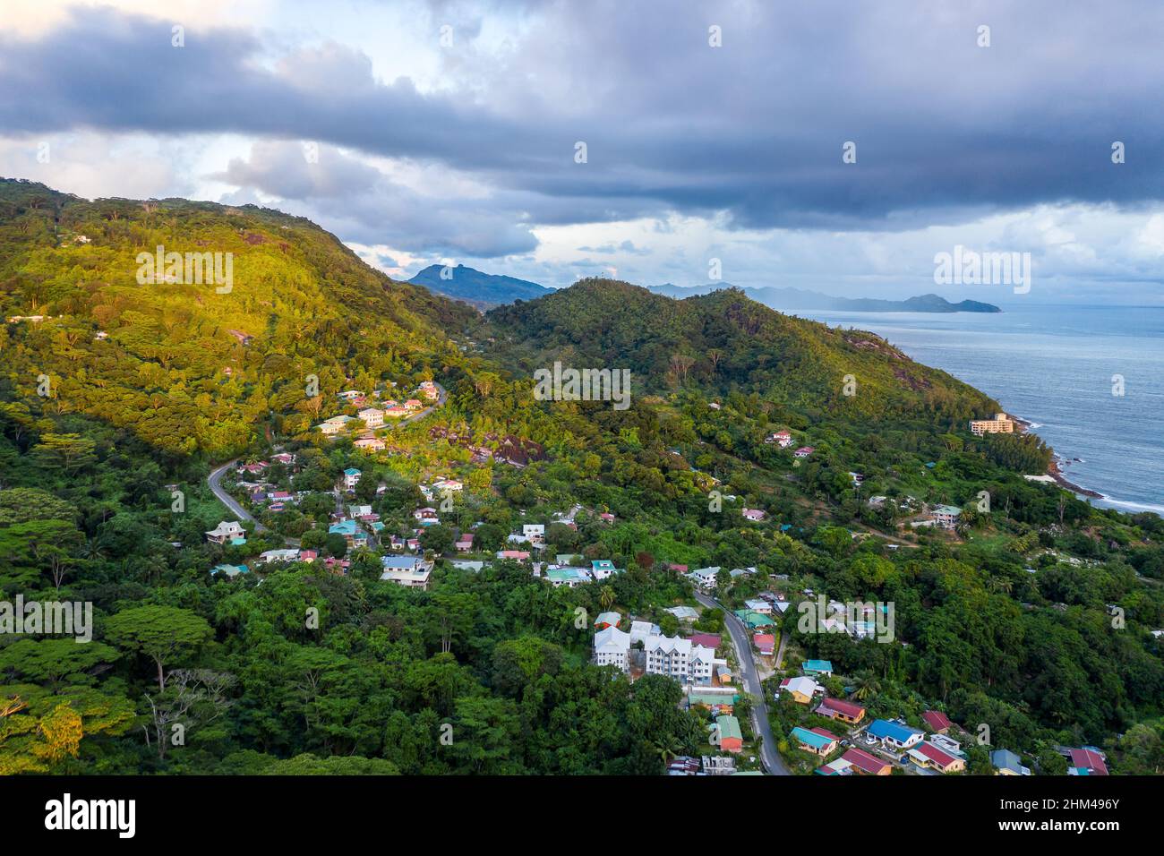 Mahe Island with Port Glaud village drone landscape, with lush tropical forest of Morne Seychellois National Park and Indian Ocean on the horizon. Stock Photo