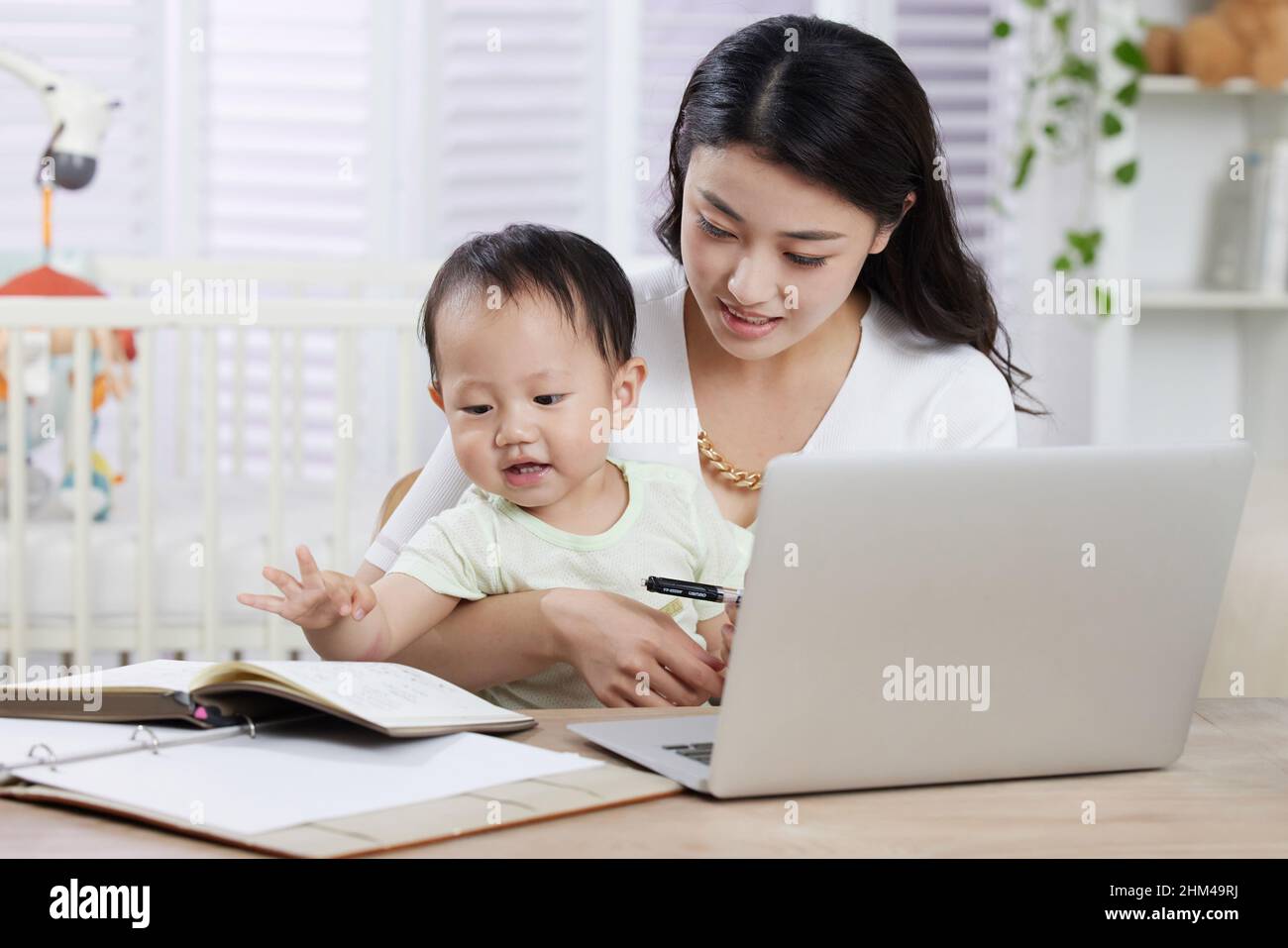 The young mother work while parenting Stock Photo