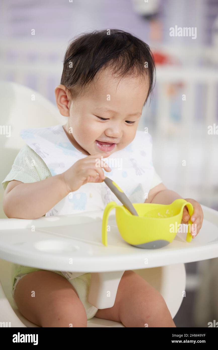 The lovely baby feed itself Stock Photo