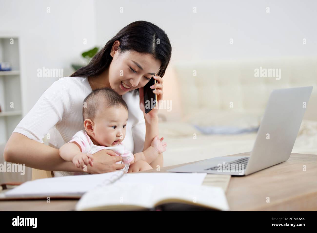 The young mother work while parenting Stock Photo