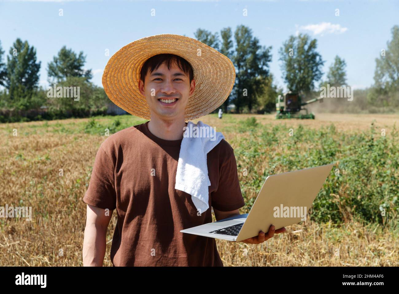 Researchers stood beside the wheat field using a computer Stock Photo