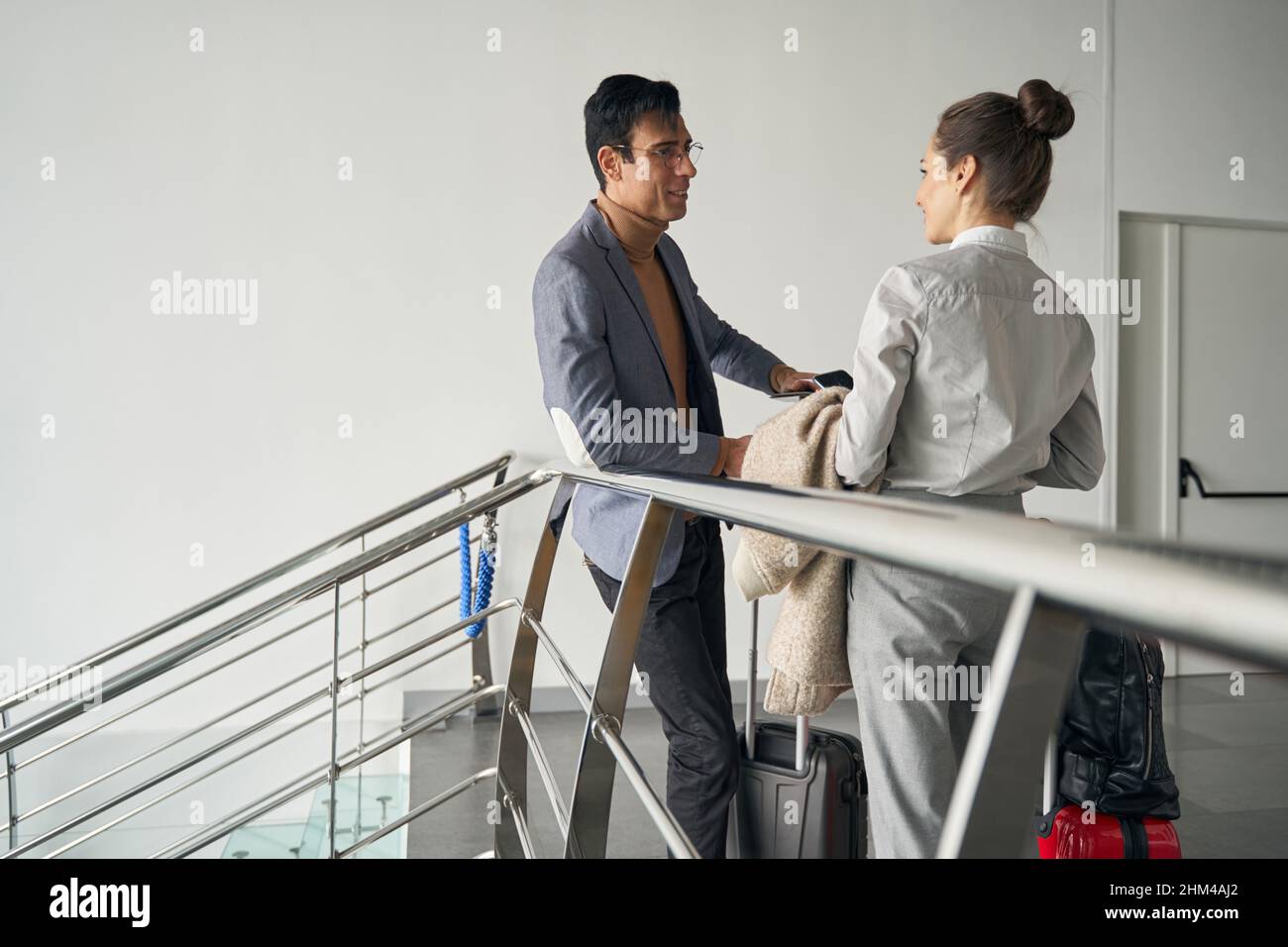 Couple with baggage standing in corridor and talking Stock Photo