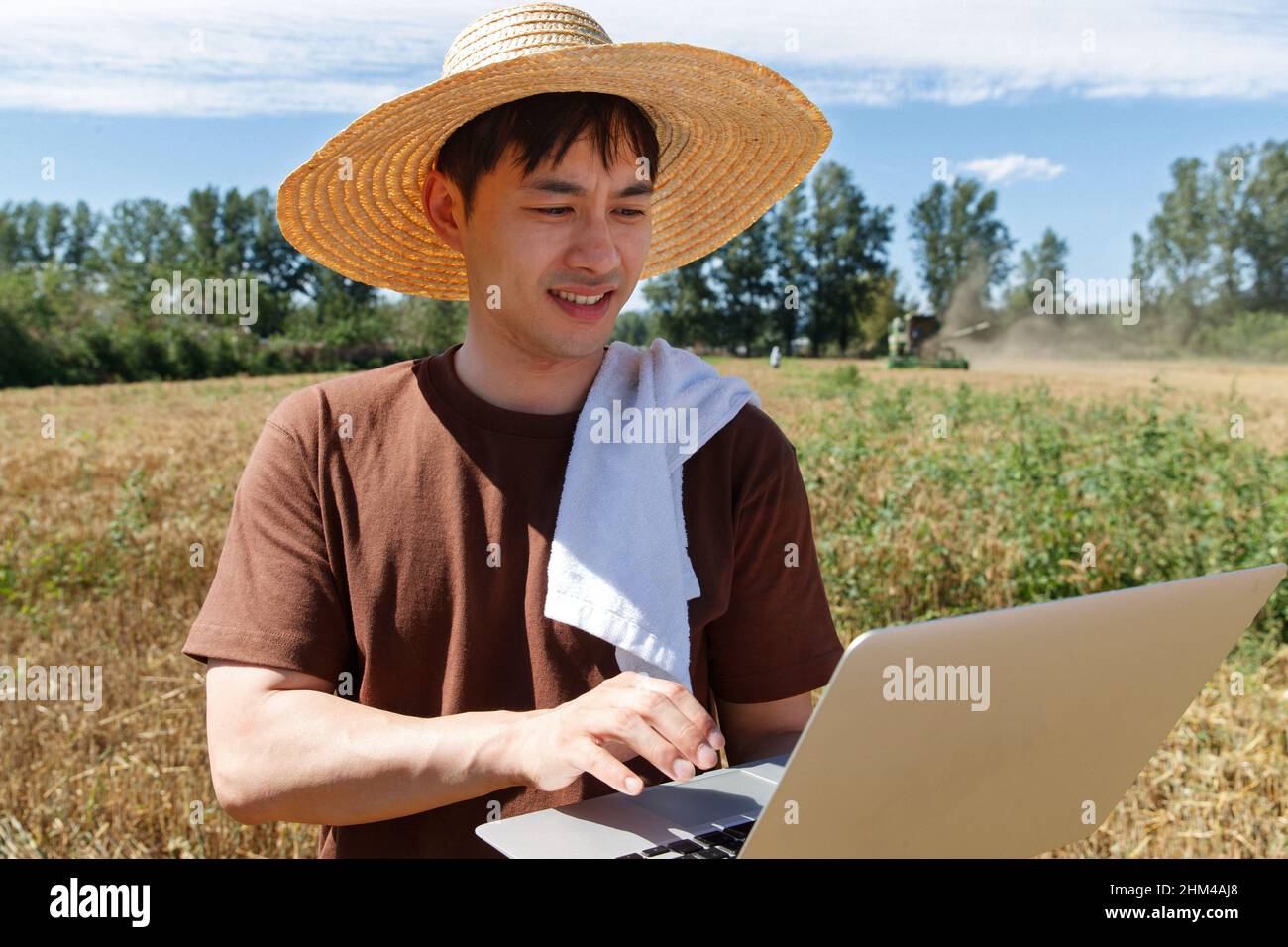 Researchers stood beside the wheat field using a computer Stock Photo
