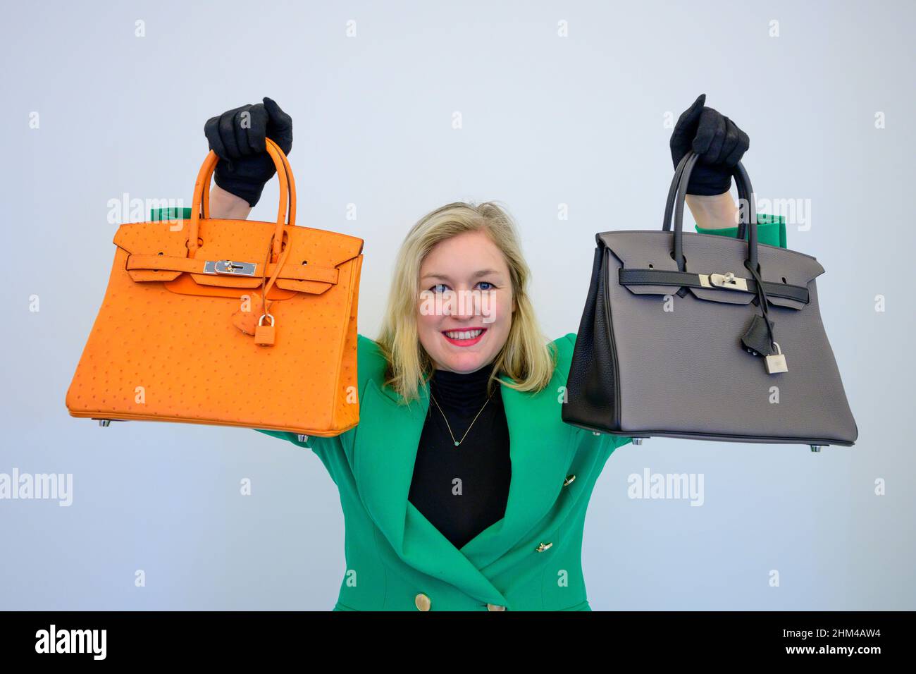 Bonhams, London, UK. 7 February 2022. Fashion sale preview with bags  representing the great houses from Chanel and Hermès to Prada and Gucci.  Image: (left): Among the bags, an Orange H Ostrich