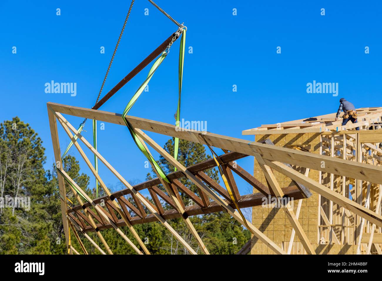 Wooden roof with crane holds a roof truss beams Stock Photo Alamy