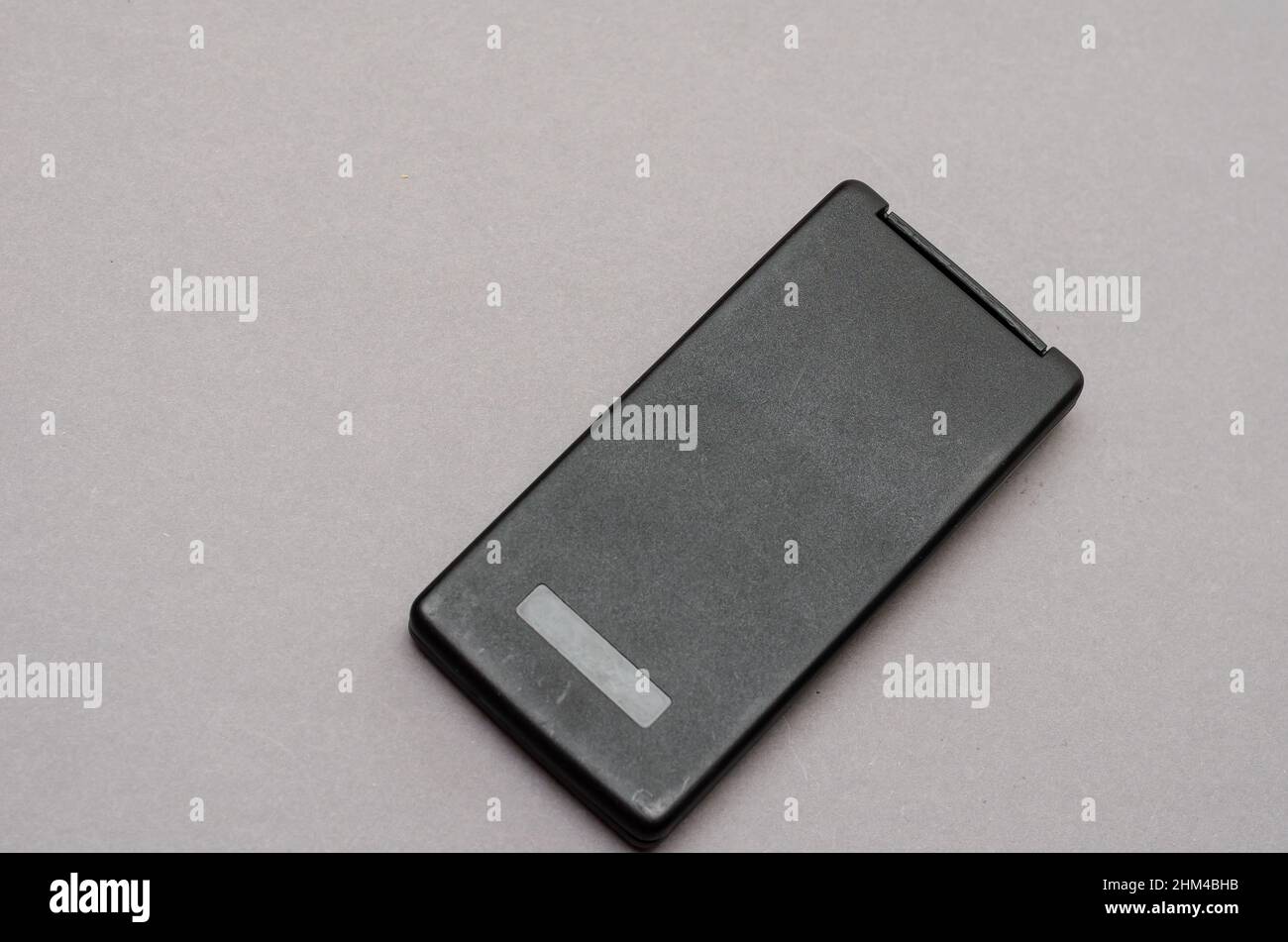 Closed Scientific calculator opposite the gray background. Rectangular