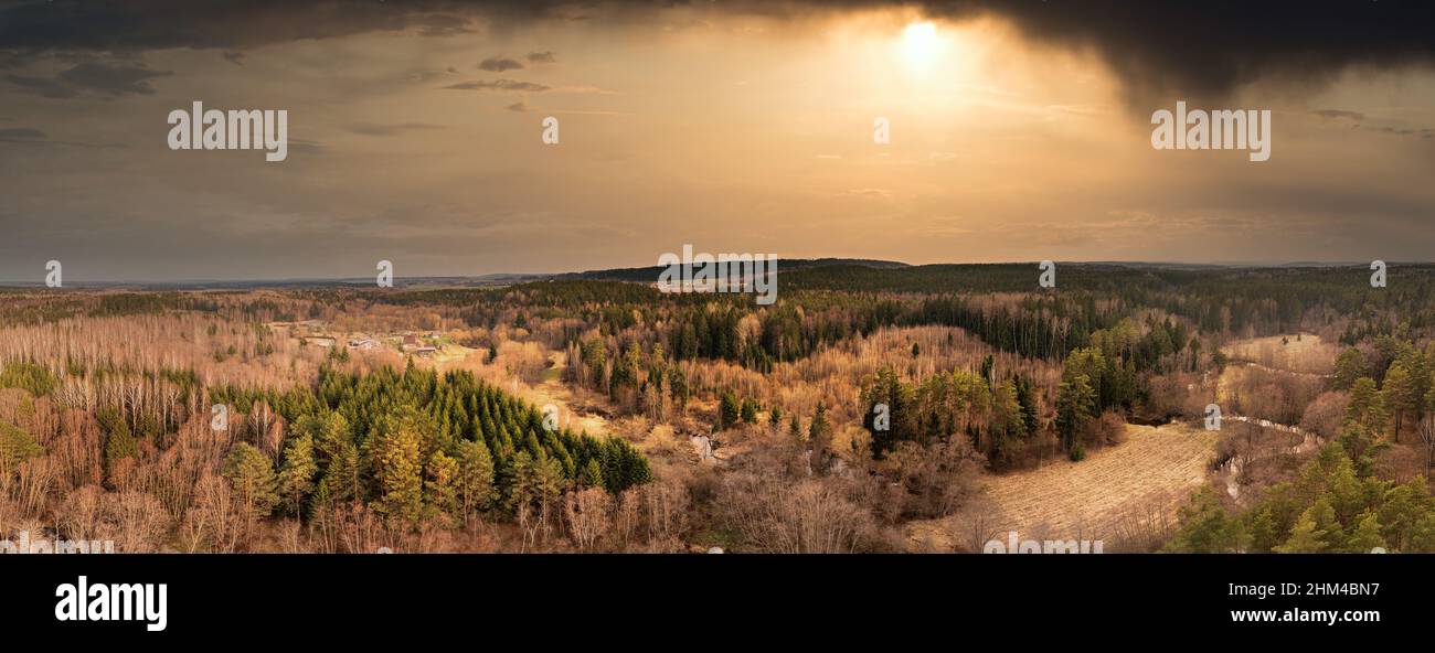 Beautiful dramatic sunset with dark clouds and sun in countryside shot from a drone Stock Photo