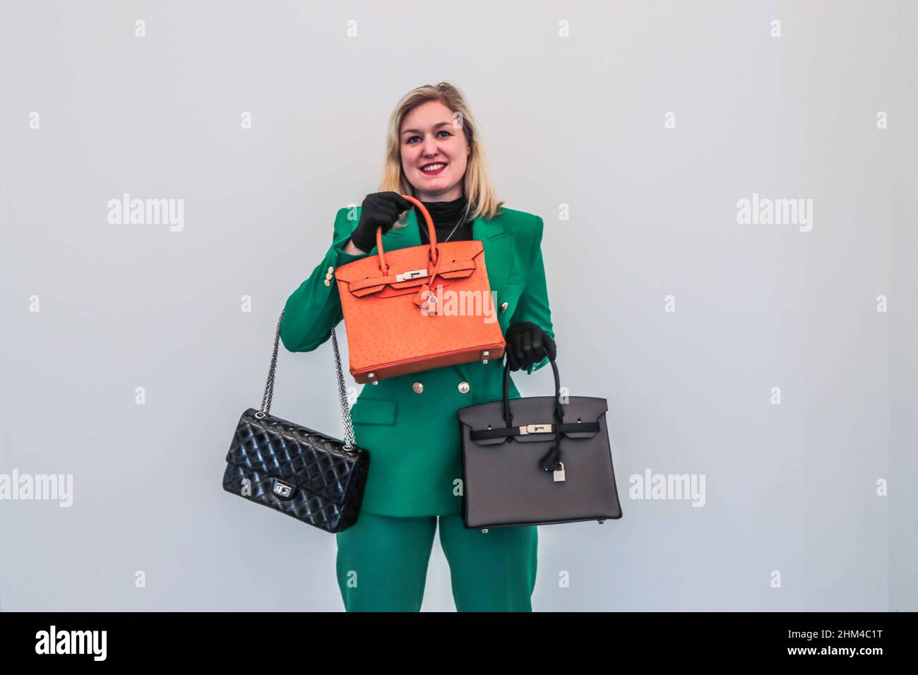 London 08 Feb 2022 Model holding (R) Orange H Ostrich Birking 30 Hermès,  2002, estimate £8,000 – 12,000 and Black aged patent Leather Reissue Double  Flap Bag Chanel, 2010-2011, a 're-issue' flap
