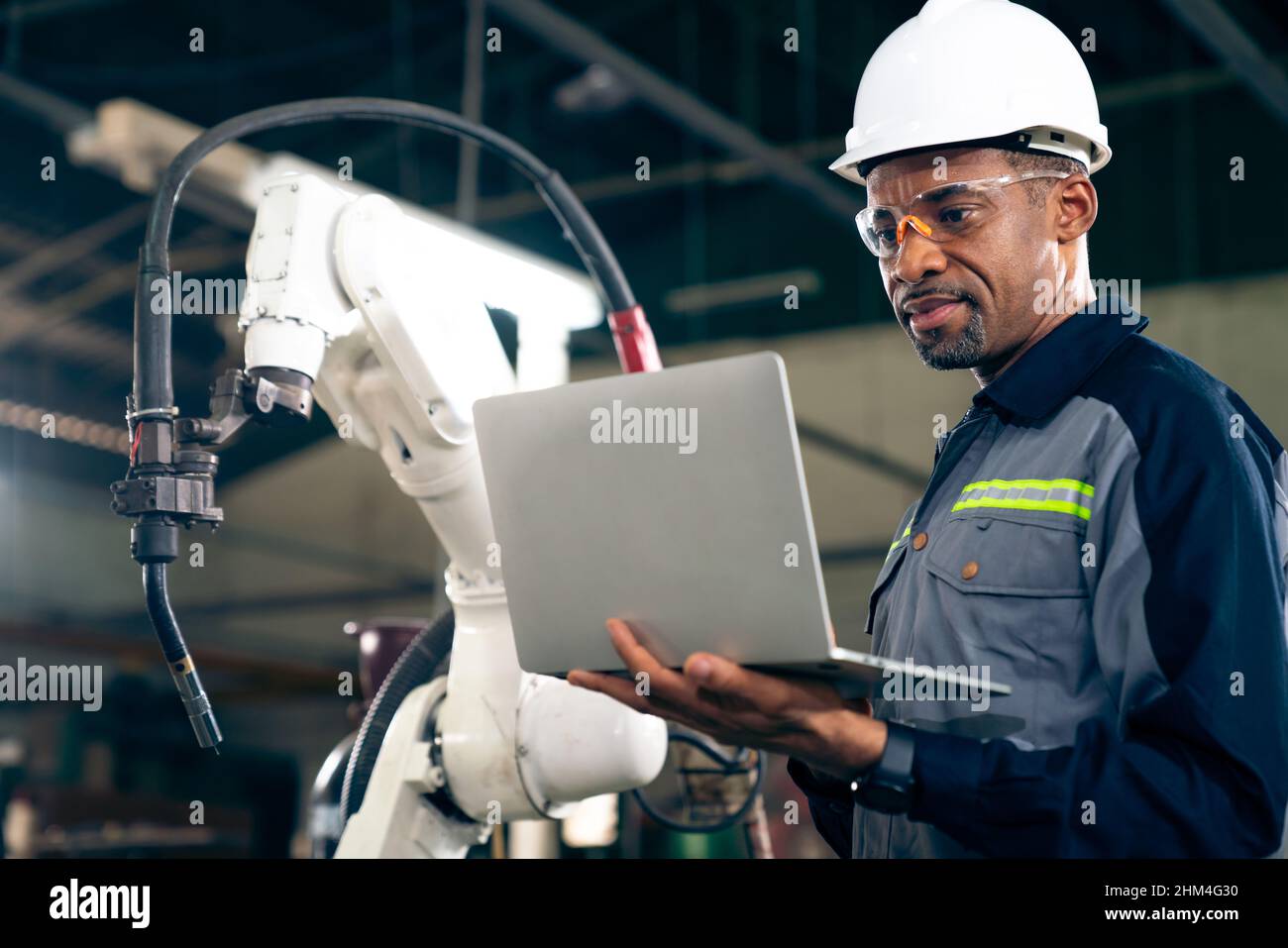 African American factory worker working with adept robotic arm in a  workshop . Industry robot programming software for automated manufacturing  Stock Photo - Alamy