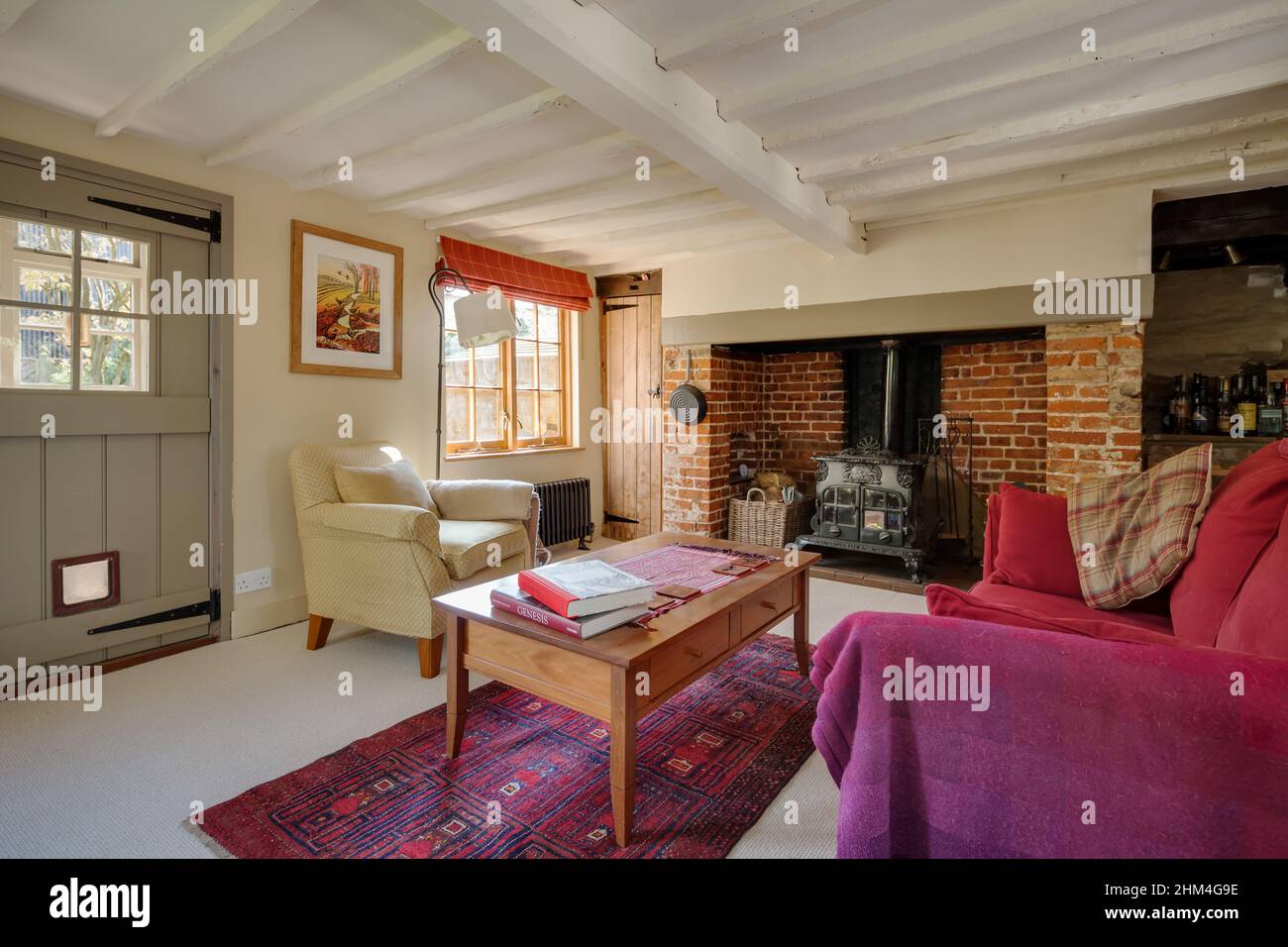 Saffron Walden, Essex - August 31 2017:  Furnished living room within traditional cottage with white painted beams and brick inglenook. Stock Photo