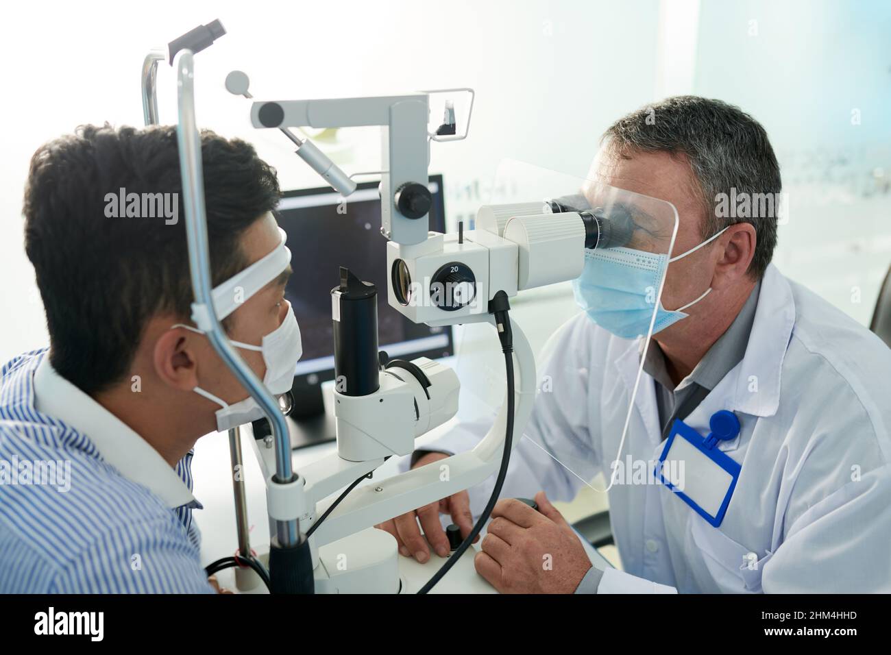 Experienced optometrist testing male patient for glaucoma with modern ...