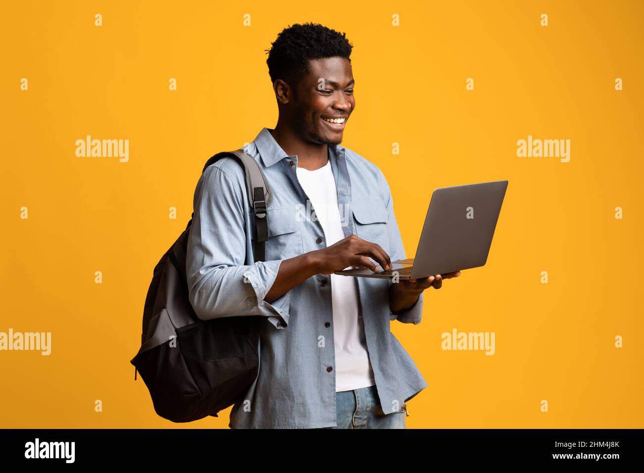 Smiling african american male student using laptop Stock Photo