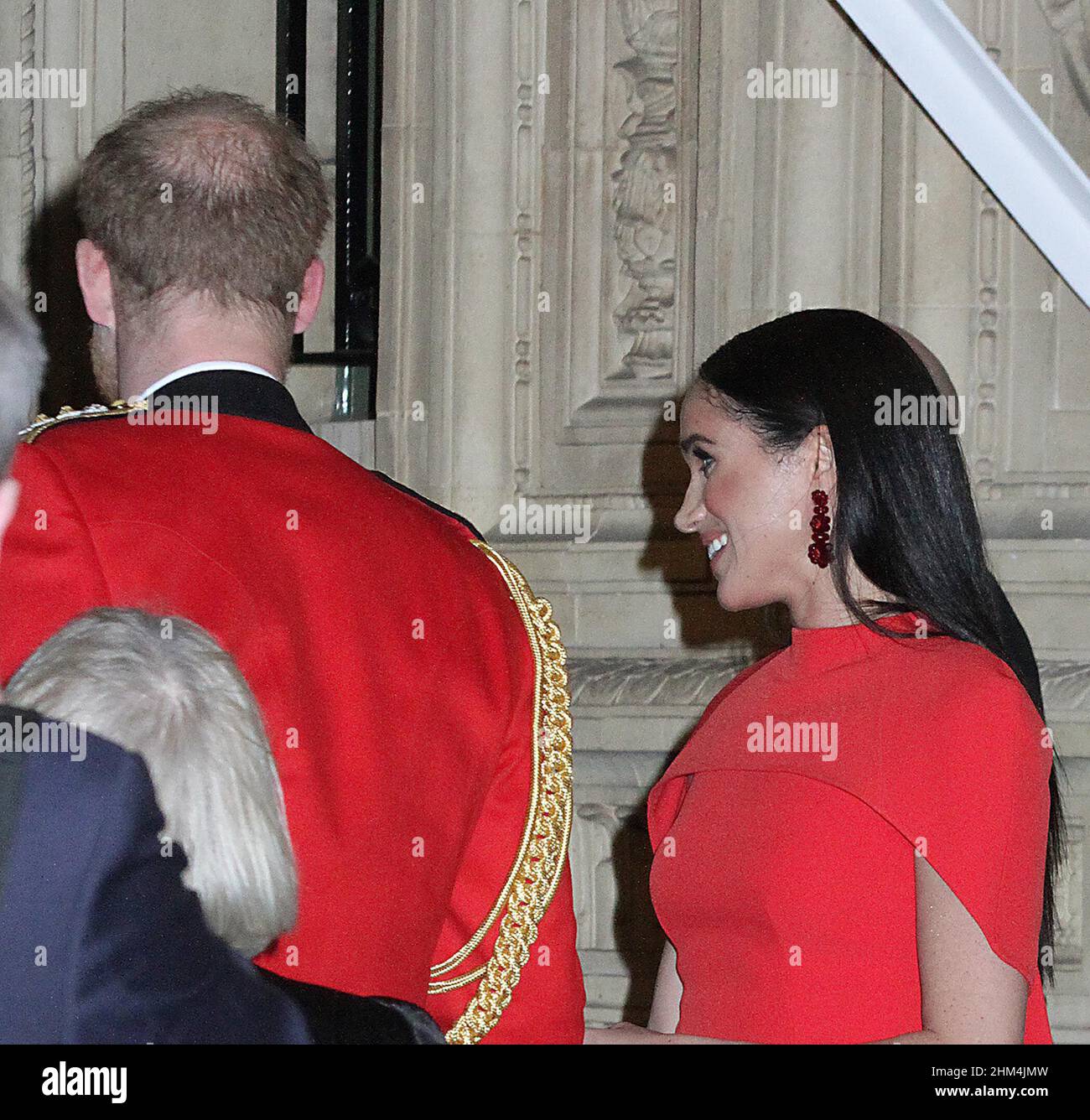 meghan markle and harry at the royal albert hall were he was wearing his army uniform as captain general for the last time.meghan looked very nice in that red dress and the said good bye to everyone before they speeded off to the palace 7/3/2020 Stock Photo