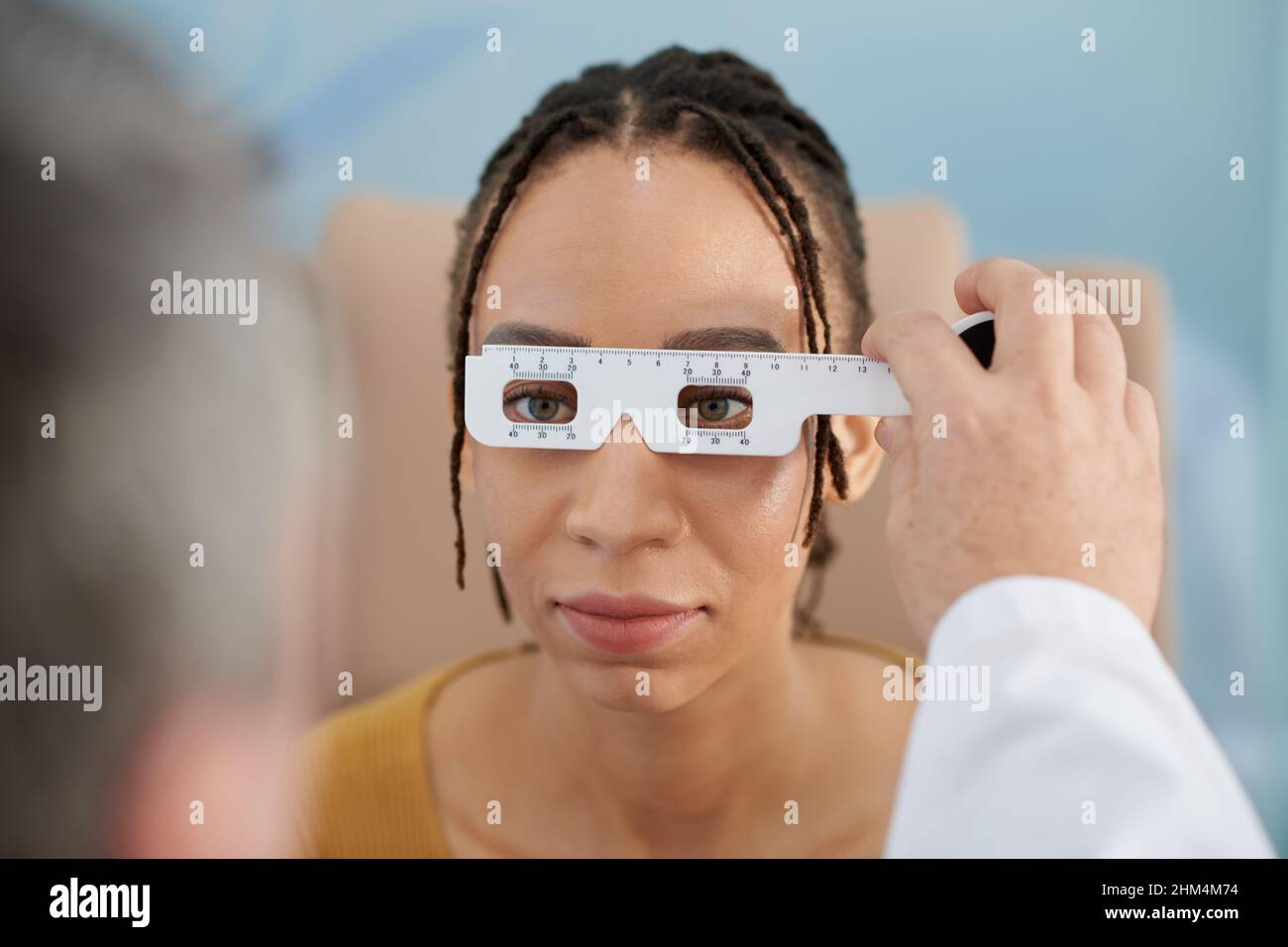 Ophthalmologist using special ruler tool to measure the distance ...