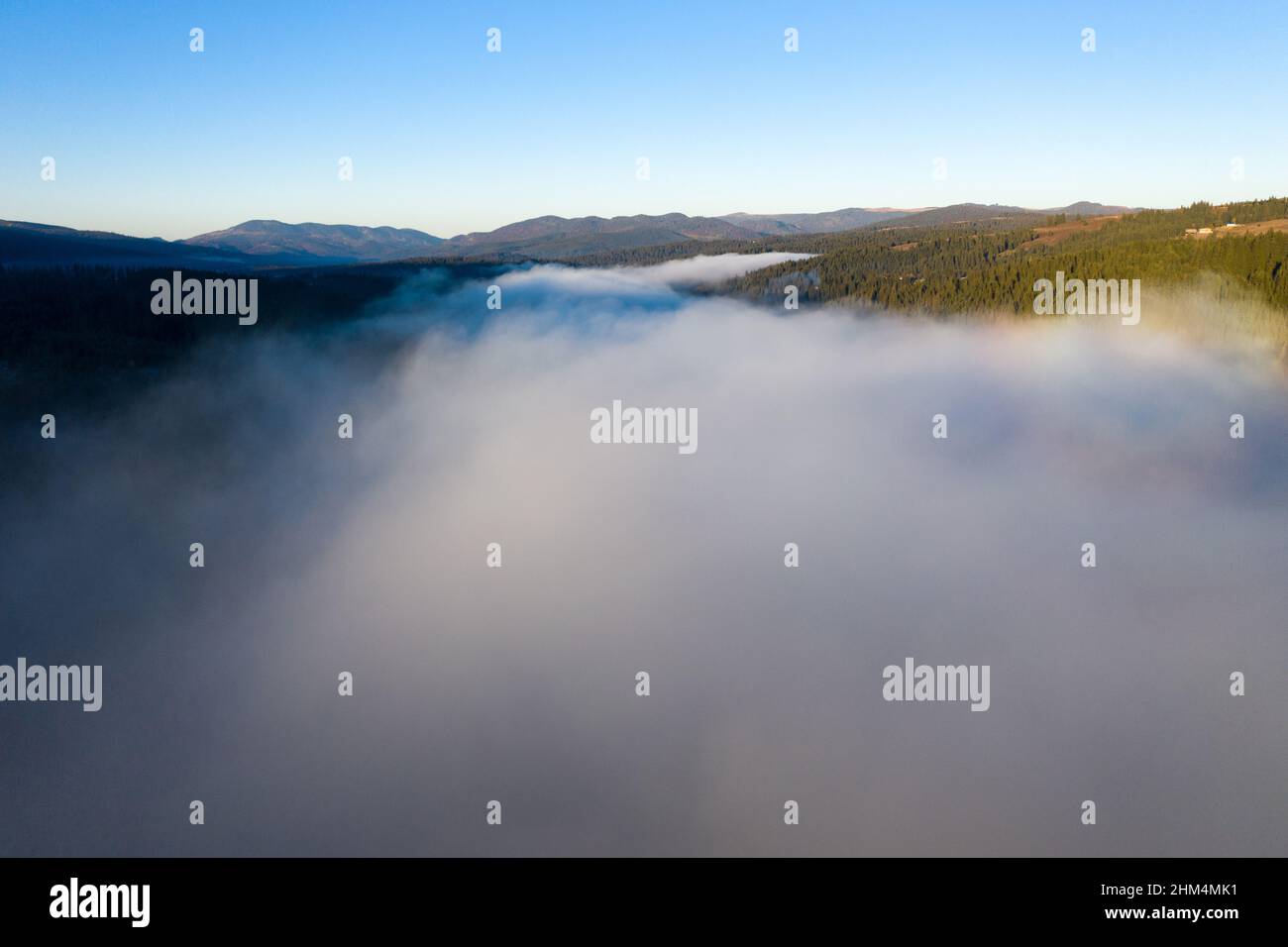 Aerial view of misty morning in the mountains. Flying above clouds and Belis lake, Romania Stock Photo