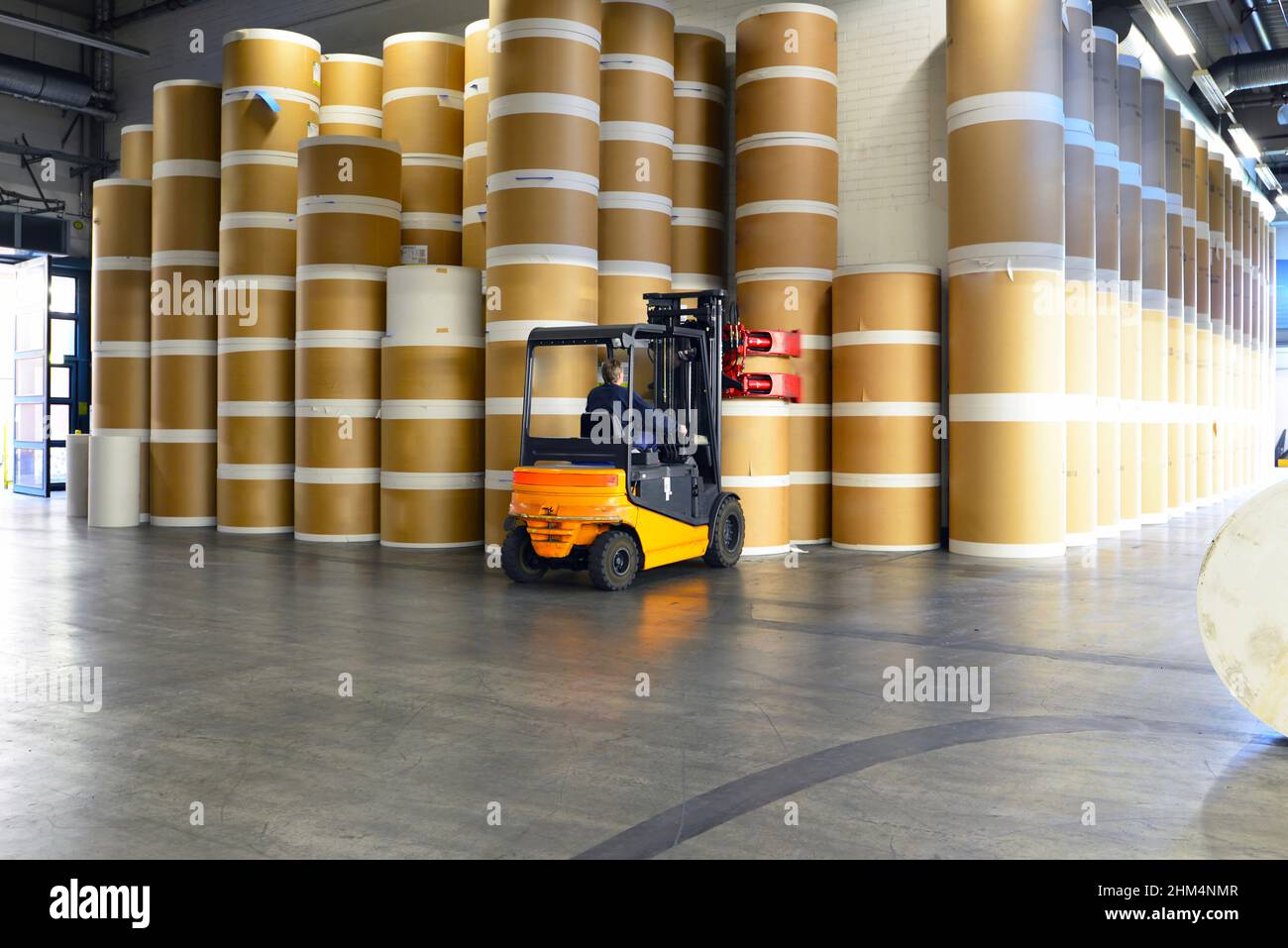 printing company - storage room with paper rolls - forklift for transportation Stock Photo