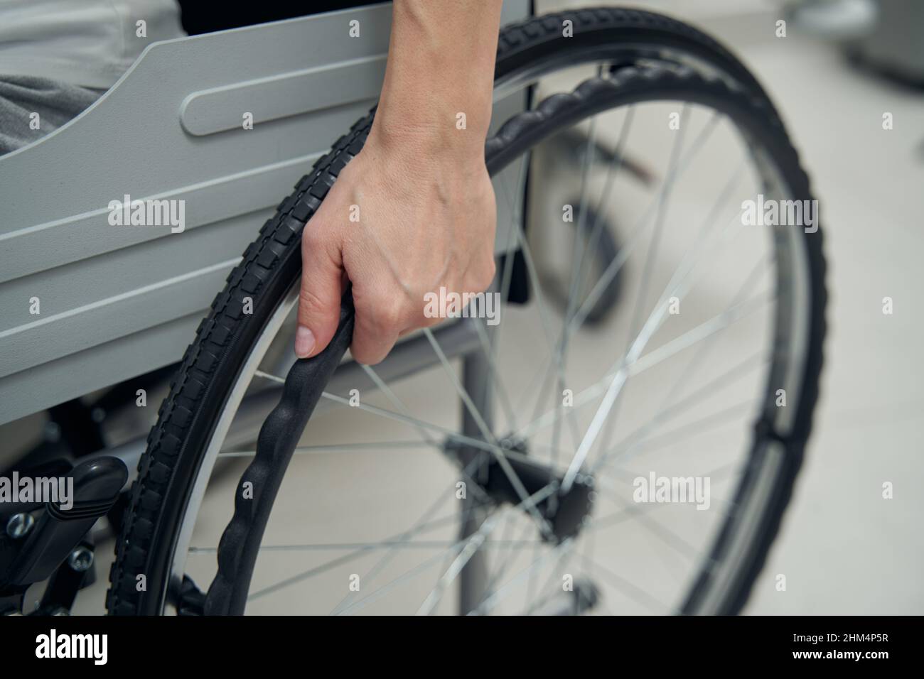 Person with disability using manually-propelled chair indoors Stock Photo
