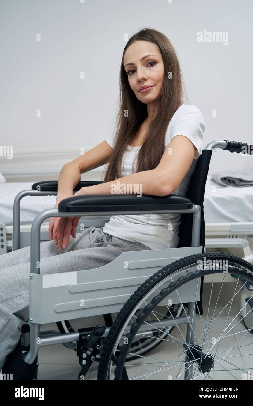 Woman with disability posing for camera in hospital ward Stock Photo