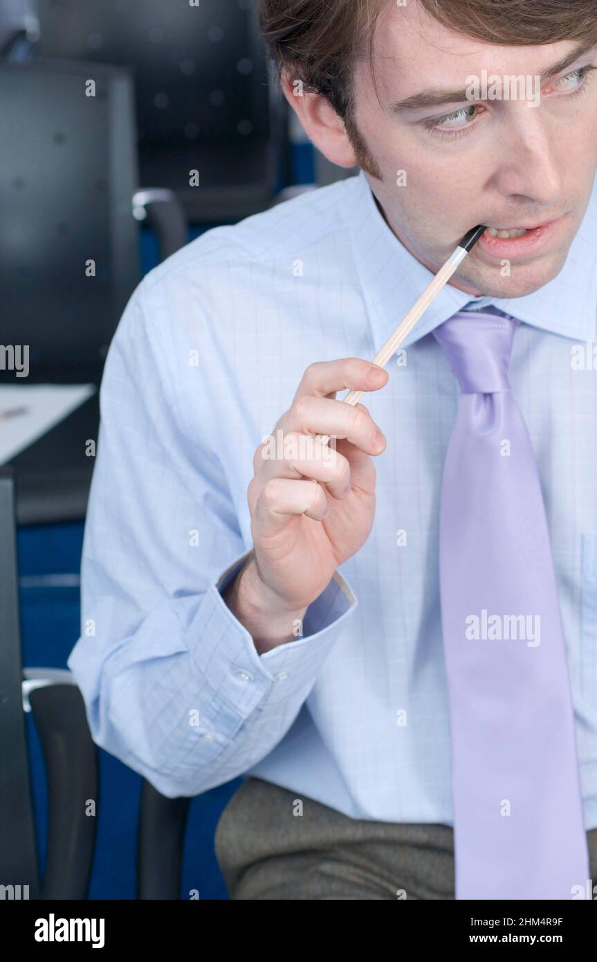 Close-Up Of A Businessman Thinking And Chewing A Pencil, Credit:Photoshot Creative / Stuart Cox / Avalon Stock Photo