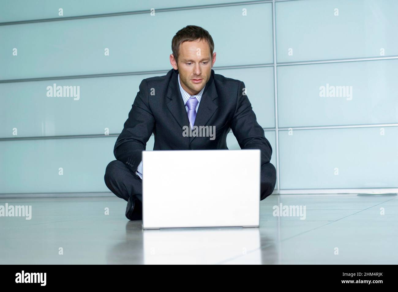 Businessman Sitting On The Floor And Using A Laptop, Credit:Photoshot Creative / Stuart Cox / Avalon Stock Photo