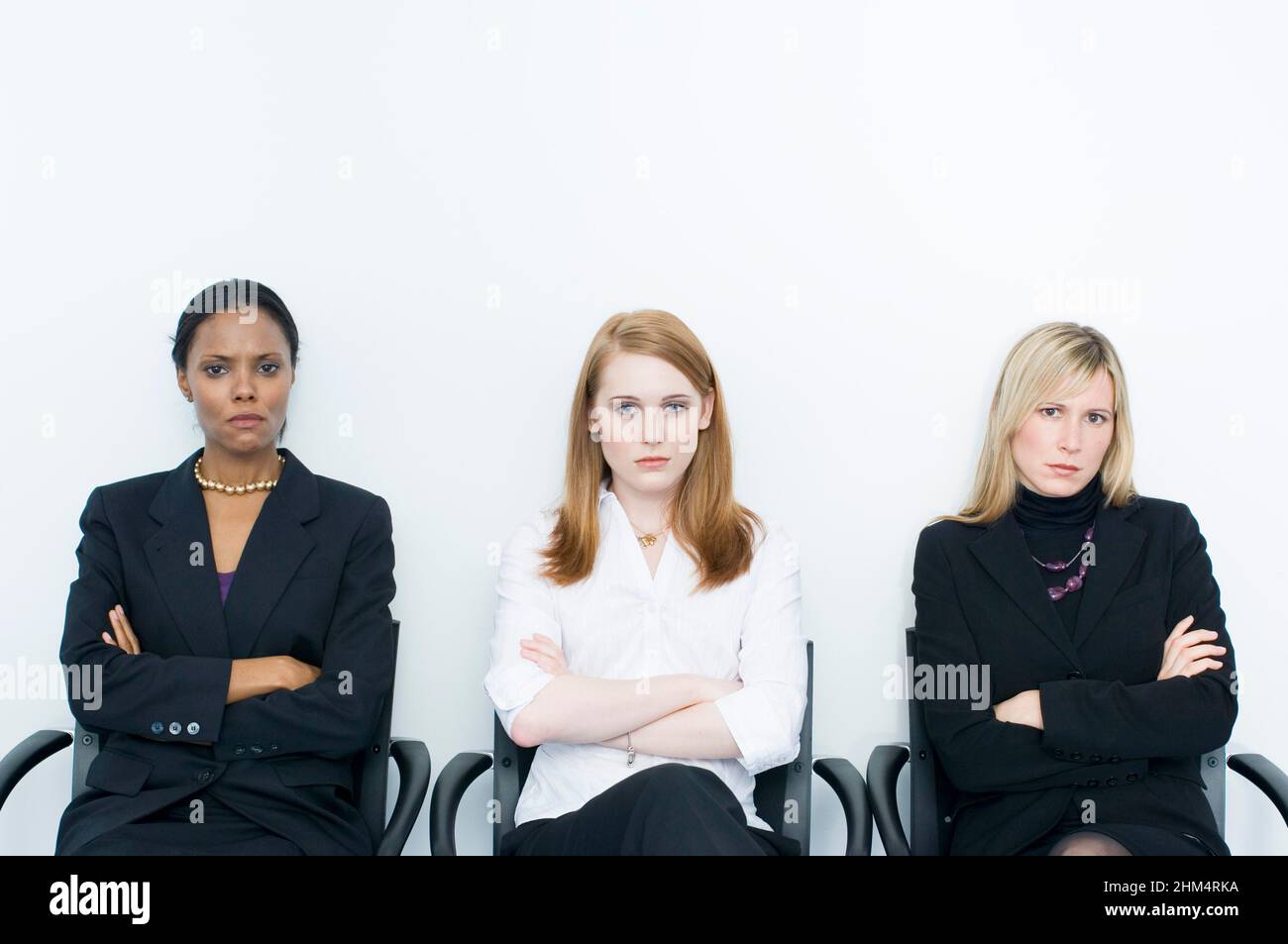 Portrait Of Three Businesswomen Sitting Side By Side And Looking Serious, Credit:Photoshot Creative / Stuart Cox / Avalon Stock Photo