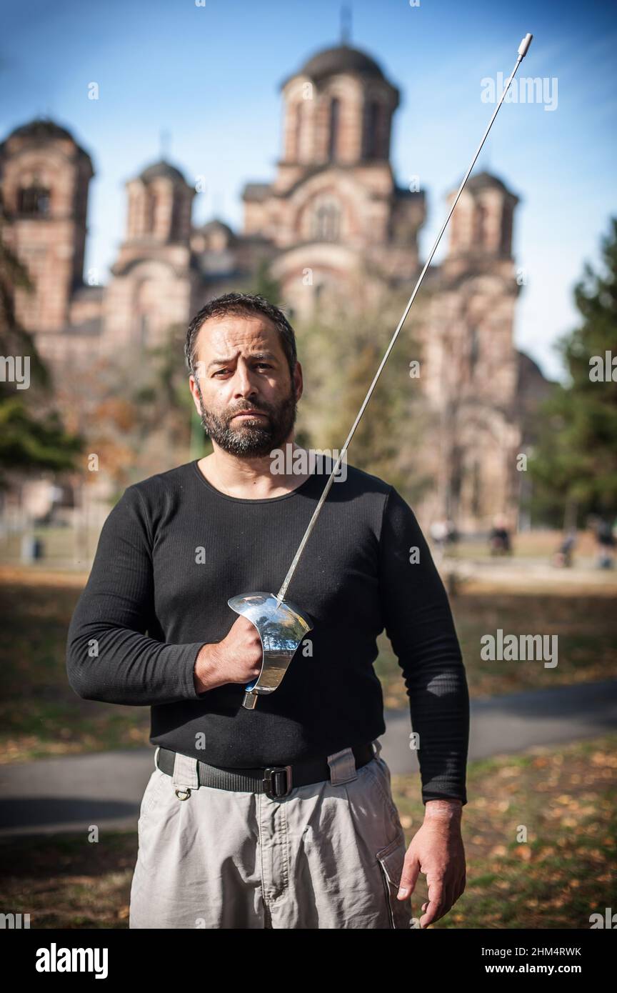 Fencing swordsman instructor demonstrates sword fighting techniques and