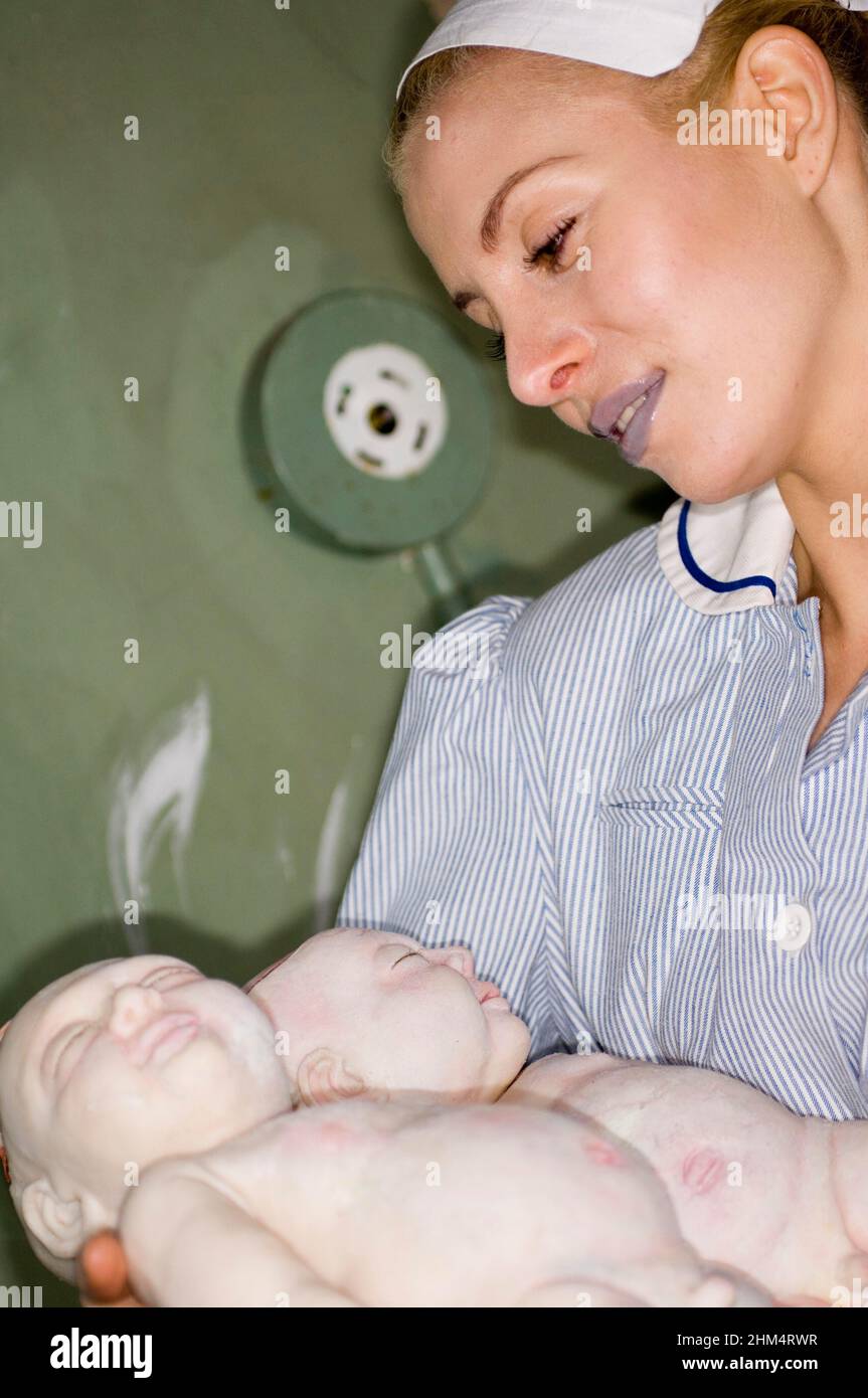Proud Nurse In Uniform Cradling Babies., Credit:Photoshot Creative / Stuart Cox / Avalon Stock Photo