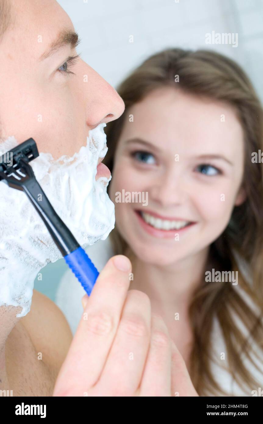 Close-Up Of A Young Man Shaving With A Young Woman Looking At Him, Credit:Photoshot Creative / Stuart Cox / Avalon Stock Photo