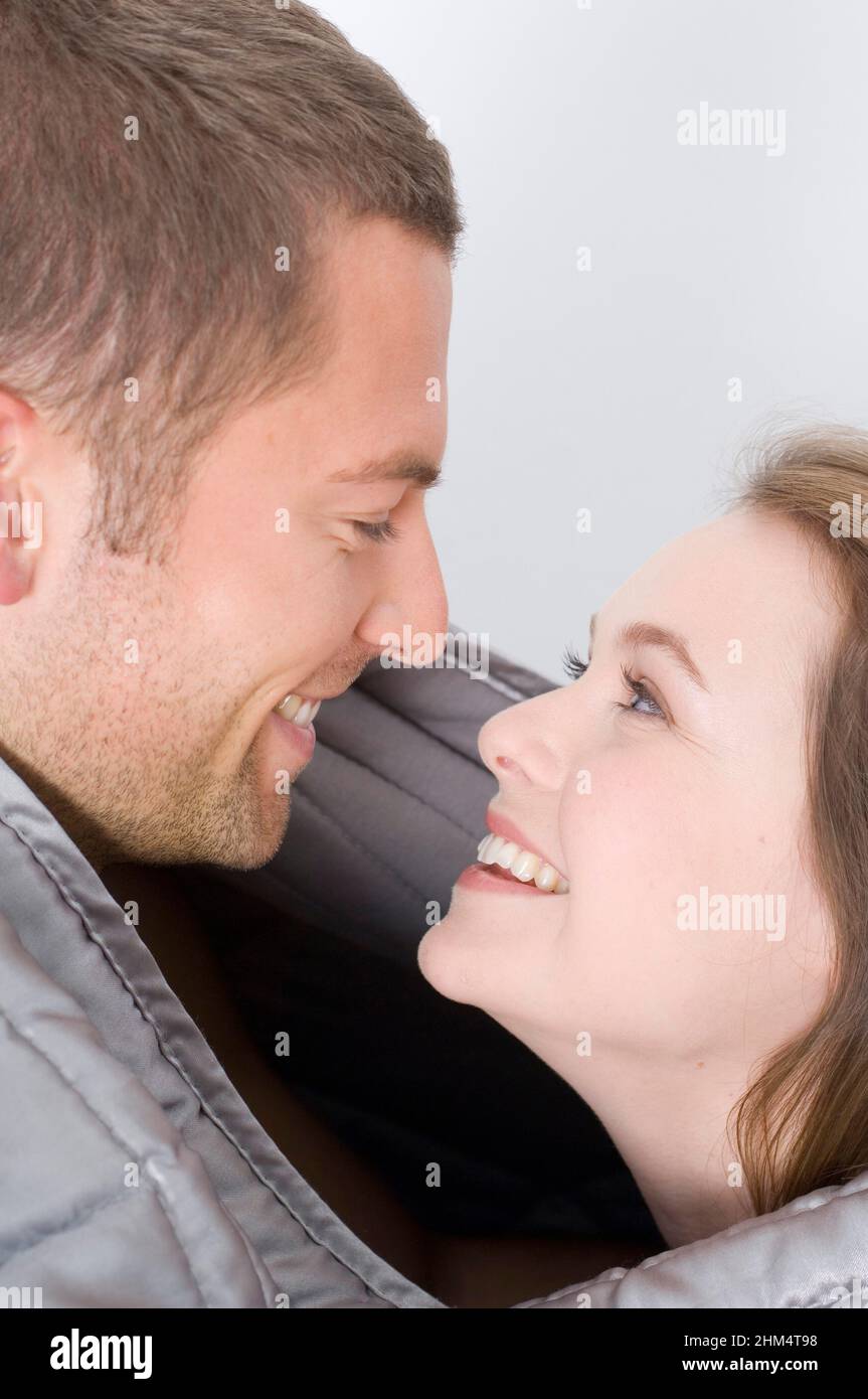 Side Profile Of A Young Couple Smiling And Looking At Each Other, Credit:Photoshot Creative / Stuart Cox / Avalon Stock Photo