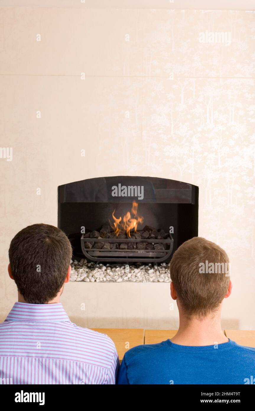 Rear View Of Two Men In Front Of A Fireplace, Credit:Photoshot Creative / Stuart Cox / Avalon Stock Photo