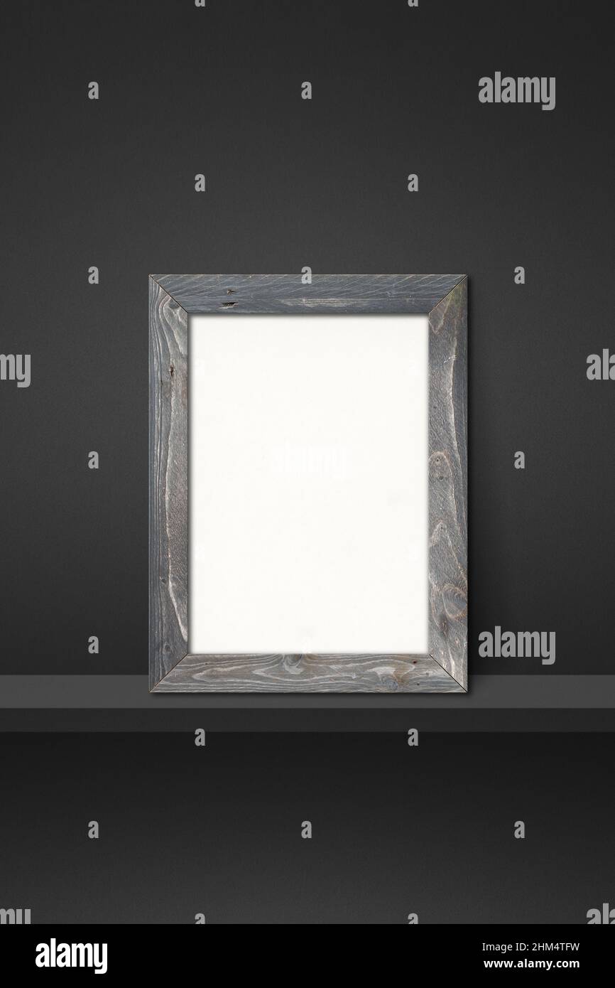 Wooden picture frame leaning on a black shelf. 3d illustration. Blank ...