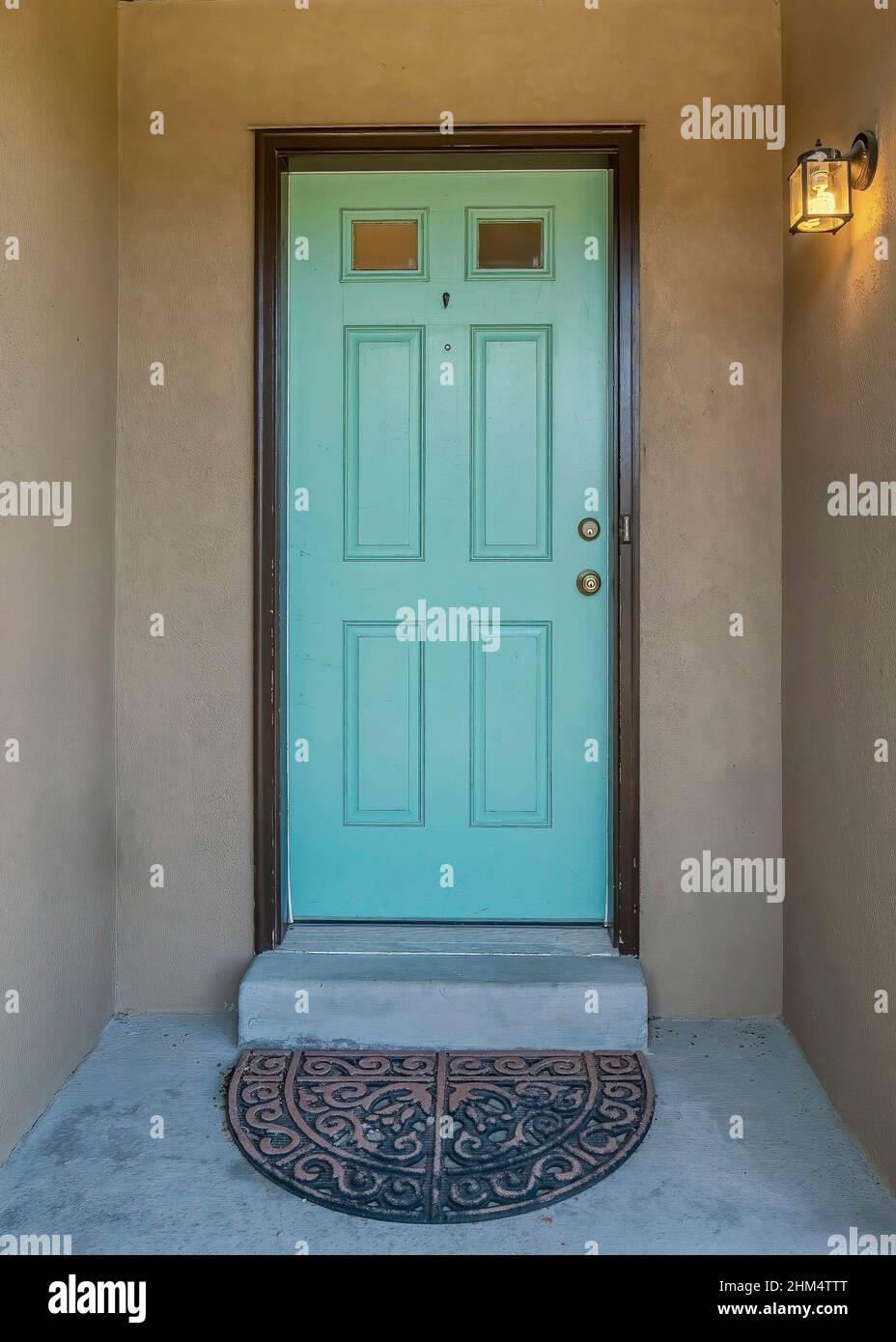 Vertical Exterior of a concrete house with mint green front door Stock