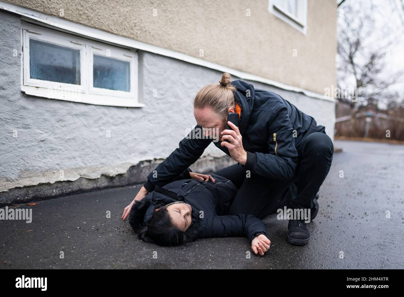 Man calling for ambulance for unconscious woman in medical shock Stock Photo