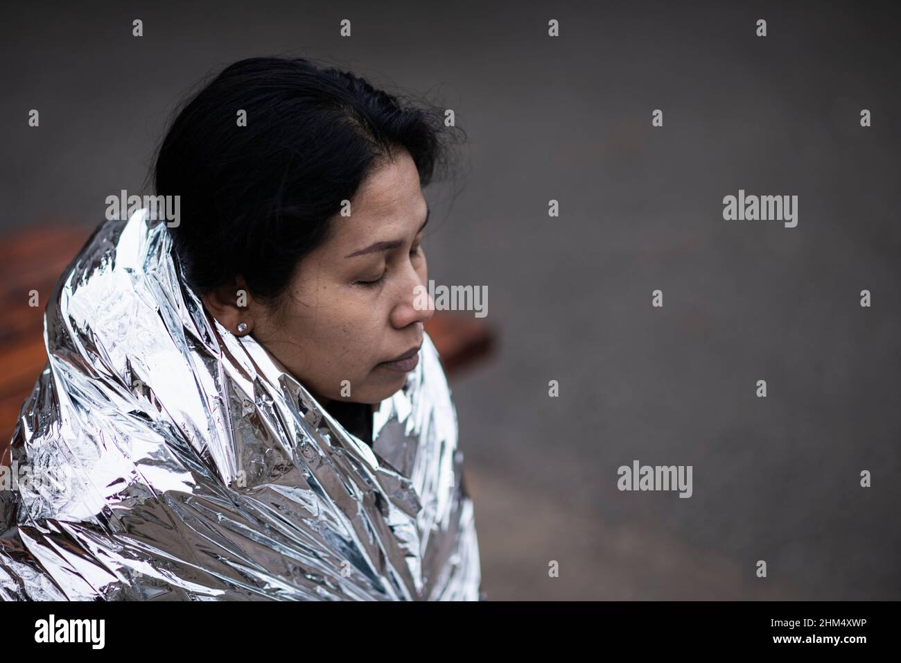 Woman wrapped in emergency blanket Stock Photo