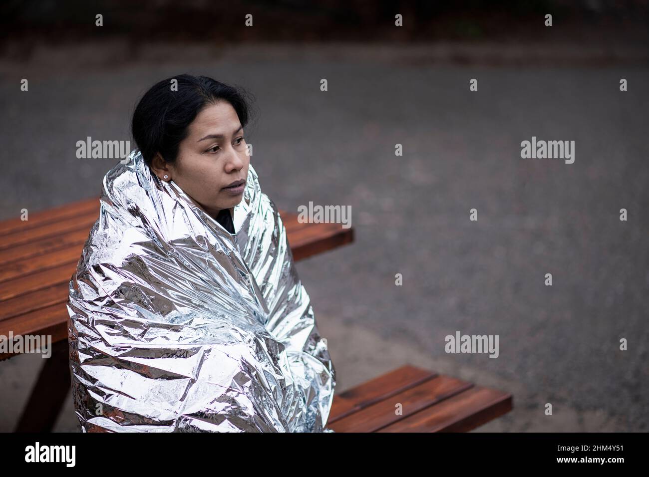 Woman wrapped in emergency blanket Stock Photo