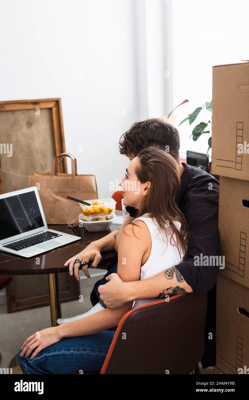 Couple sitting at table and using laptop Stock Photo