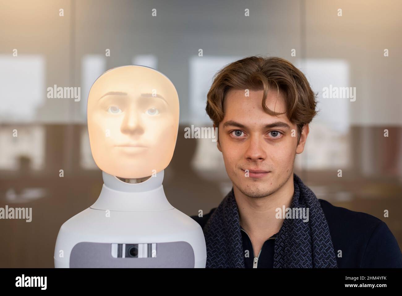 Portrait of young man with robot voice assistant Stock Photo