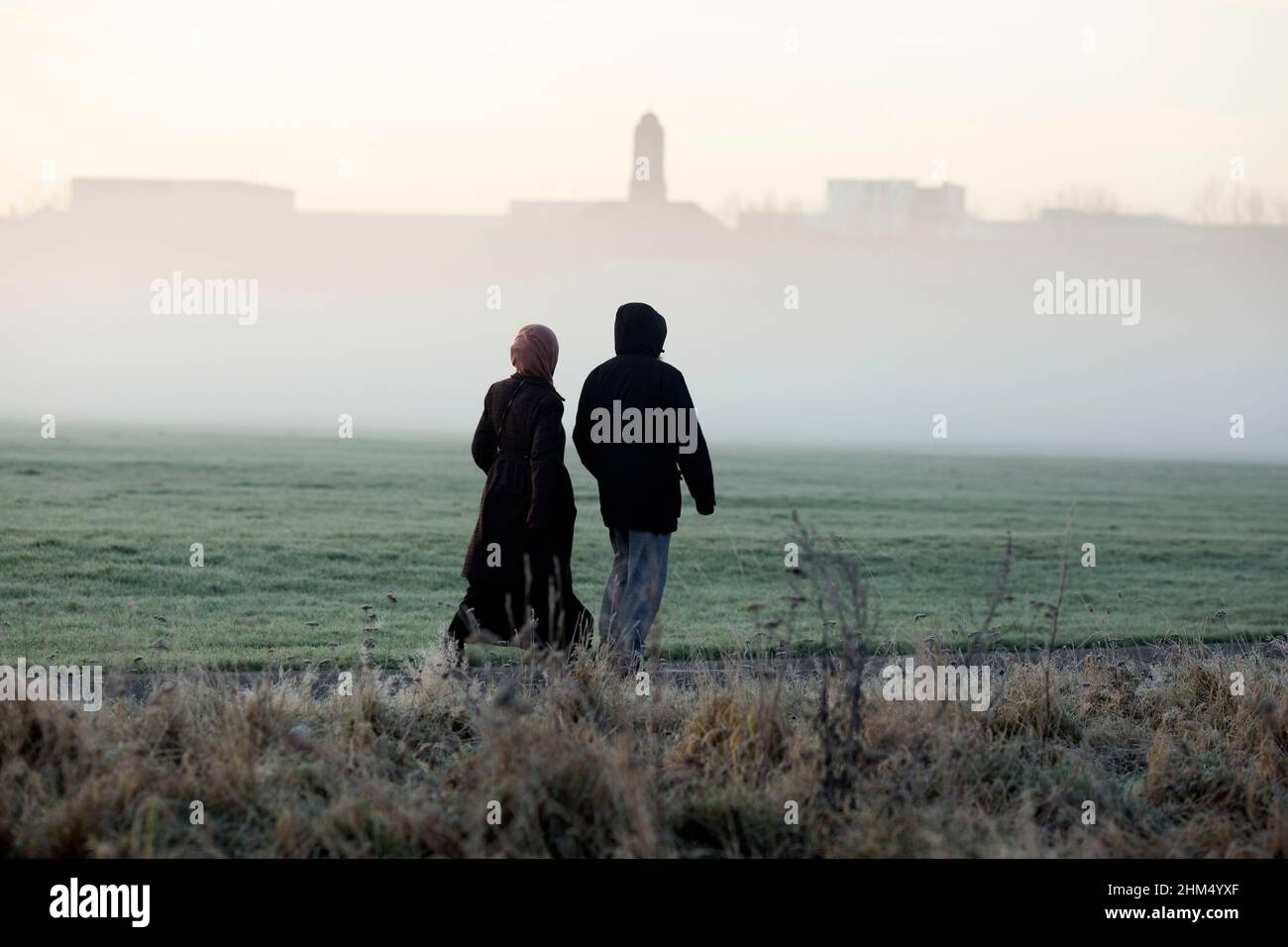 Pedestrians walk in a mistcovered park in Ilford, East London, in the