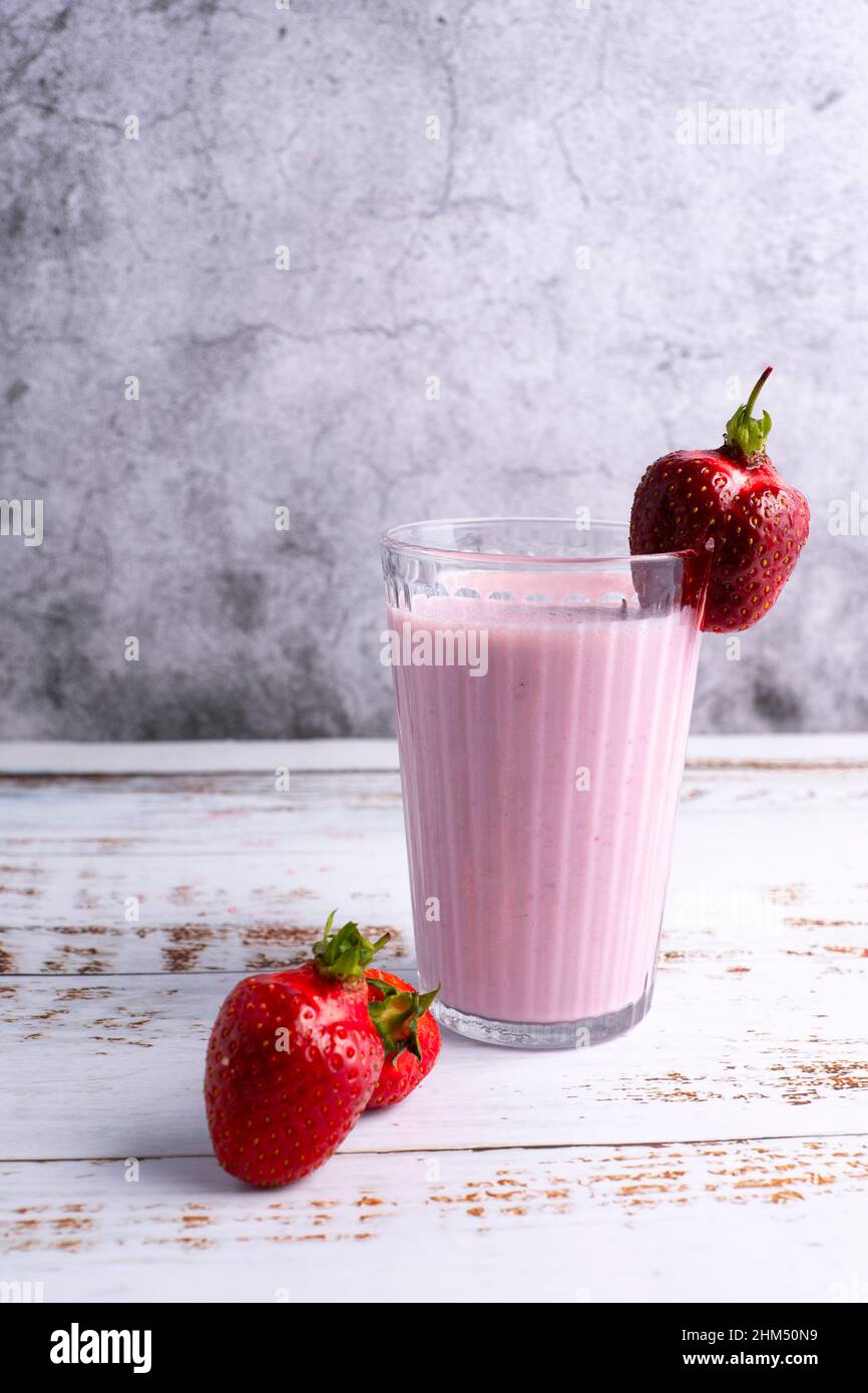 Homemade strawberry milk decorated with fresh strawberries. Stock Photo