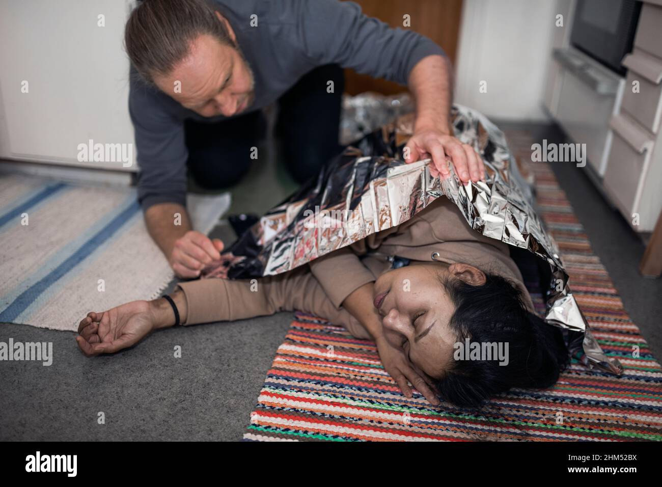 Man taking care of unconscious woman in medical shock Stock Photo