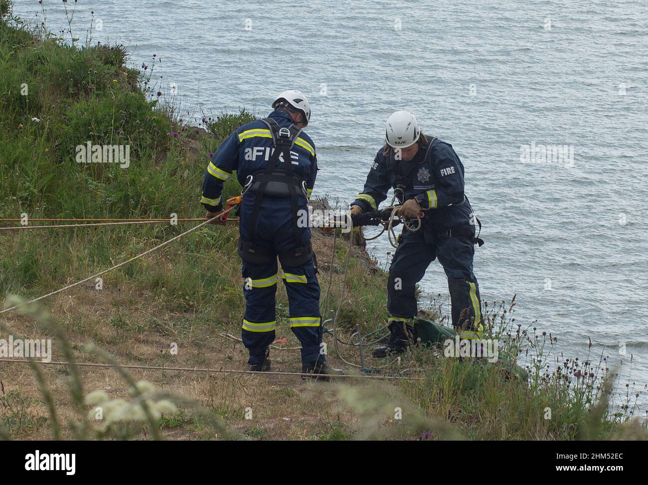 Firemen on a cliff rescue training exercise ready to descend a coastal cliff on the North East coast. Stock Photo
