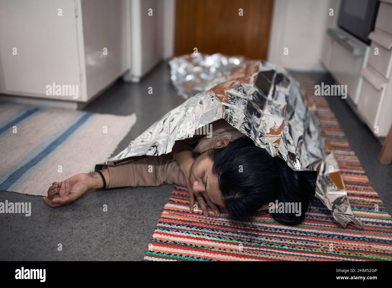 unconscious woman in medical shock lying under emergency blanket Stock Photo