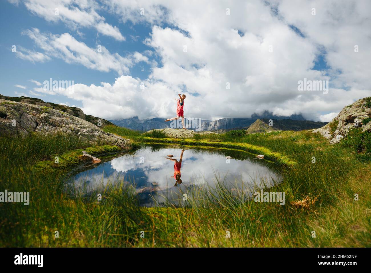 Woman jumping at mountain lake Stock Photo
