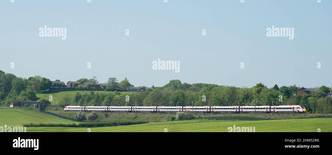 Train in LNER livery heading across open farmland in County Durham Stock Photo