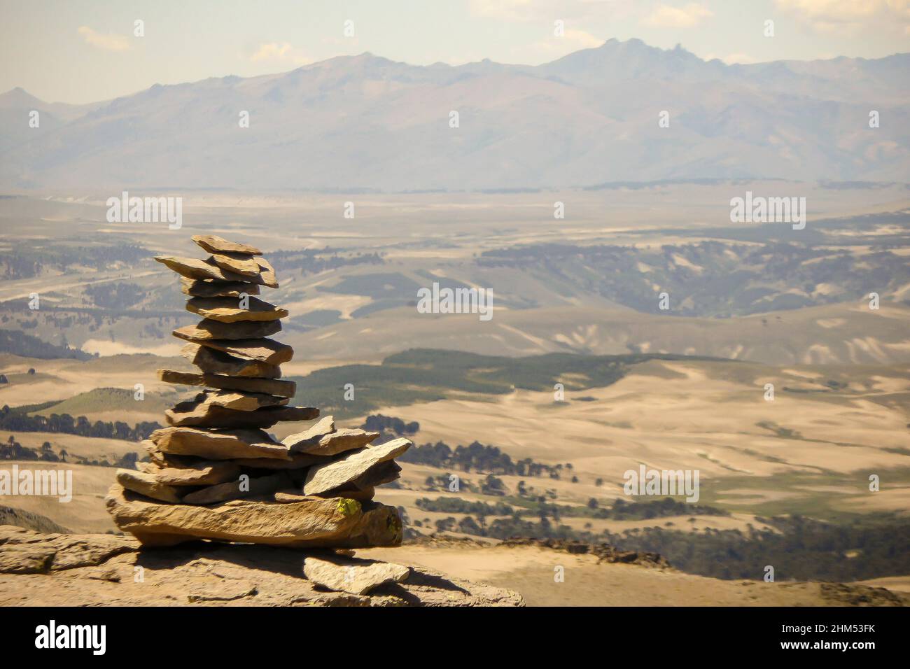 Plain stones stacked called apacheta with some moutains at the background in Villa Pehuenia, Neuquén, Argentina. Stock Photo